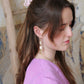 Gorgeous young woman wearing the Beth earrings in beige with a radiant brass element by the brand Dress To Finesse. This brand is created by Anna De Ceulaer in Antwerp, Belgium. The Beth earrings are made of clay and are very lightweight.