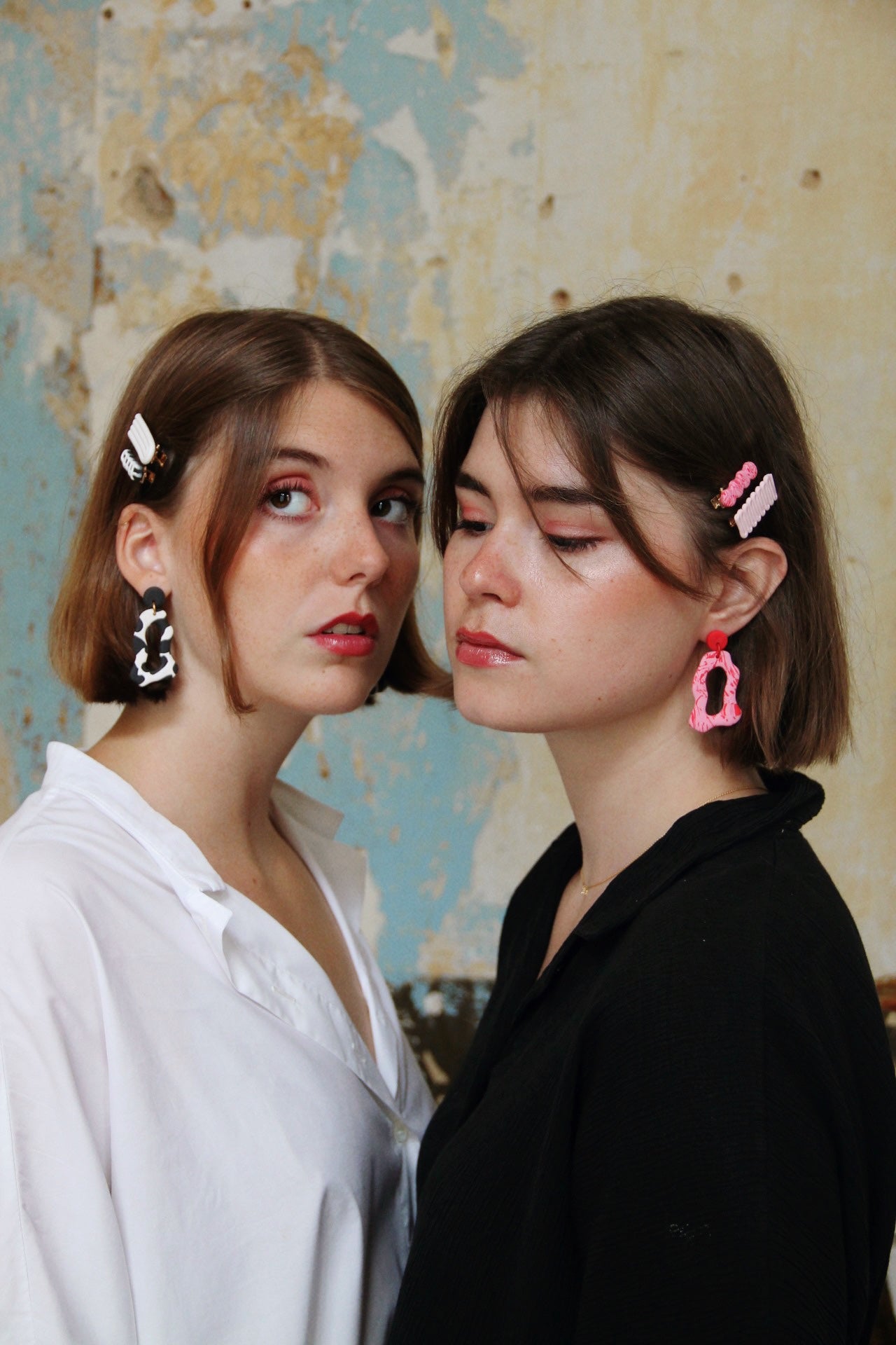 Gorgeous young women wearing the ANNA earrings in cow print and pink by the brand Dress To Finesse. This brand is created by Anna De Ceulaer in Antwerp, Belgium. The ANNA earrings are made of clay and are very lightweight. The models are wearing the DAEN hair clips in matching colours.