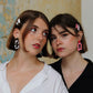 Gorgeous young women wearing the ANNA earrings in cow print and pink by the brand Dress To Finesse. This brand is created by Anna De Ceulaer in Antwerp, Belgium. The ANNA earrings are made of clay and are very lightweight. The models are wearing the DAEN hair clips in matching colours.