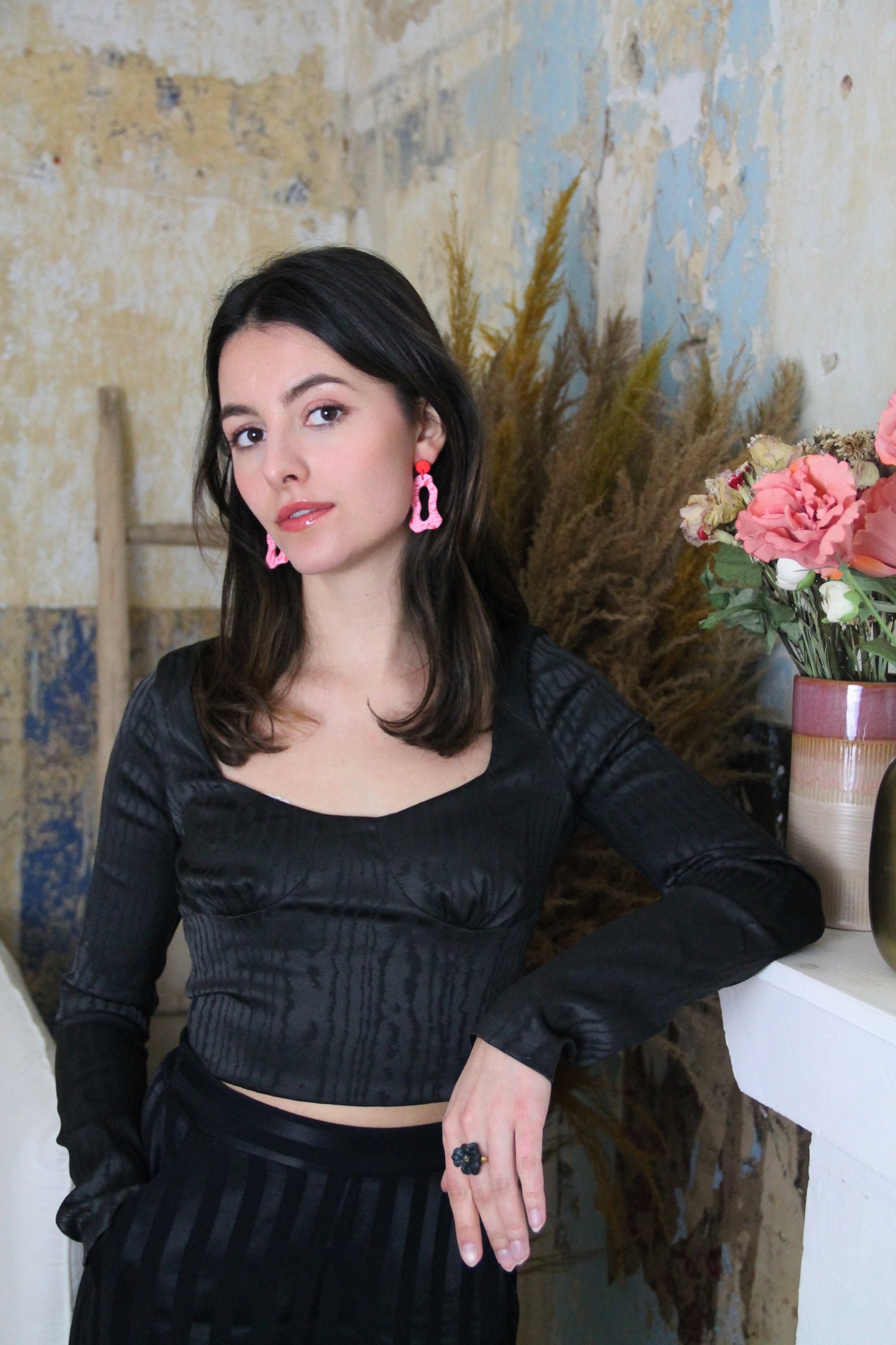 Gorgeous young woman wearing the ANNA earrings in pink and red by the brand Dress To Finesse. This brand is created by Anna De Ceulaer in Antwerp, Belgium. The ANNA earrings are made of clay and are very lightweight. 