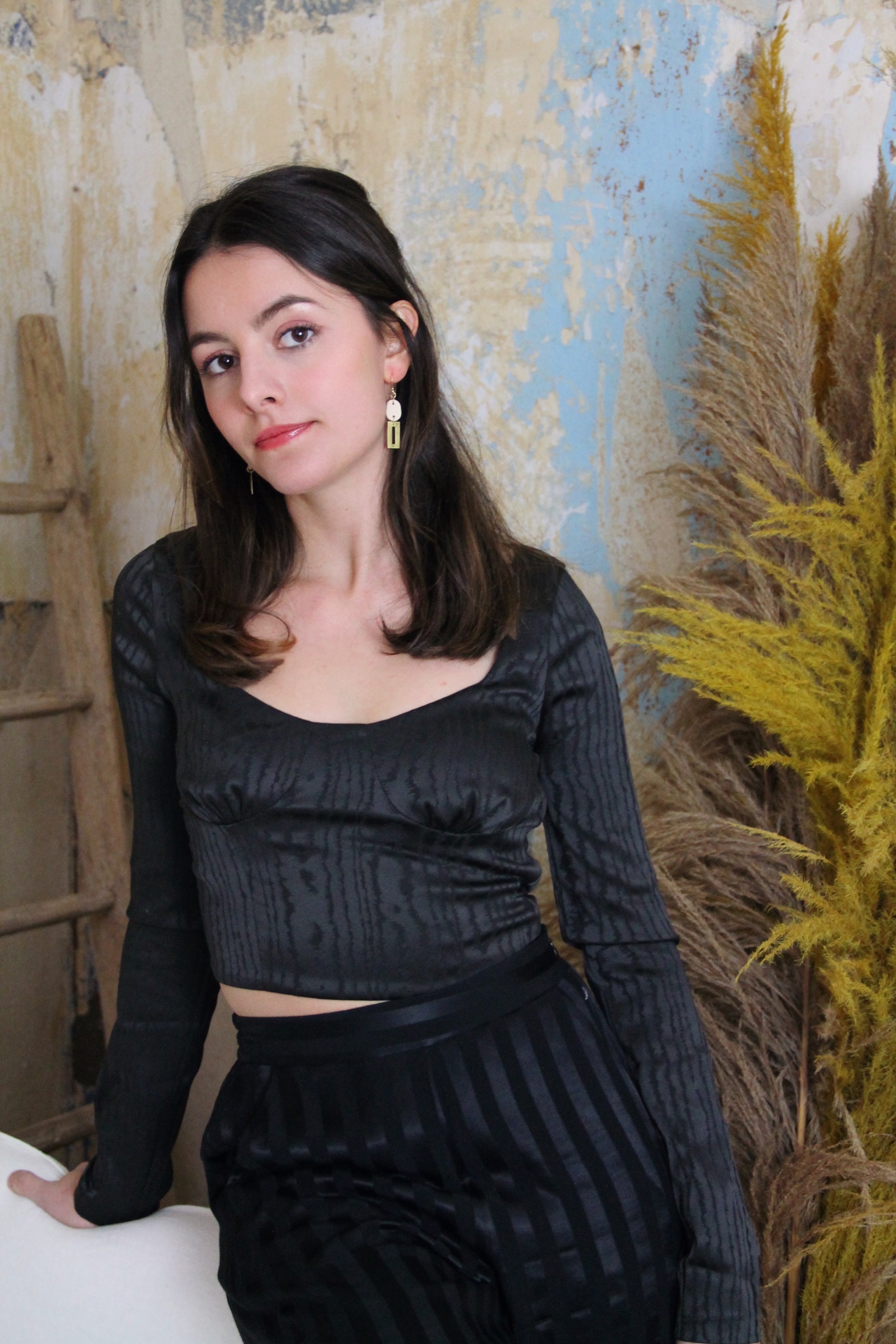 Gorgeous young woman wearing the Betty earrings in beige with a radiant brass element by the brand Dress To Finesse. This brand is created by Anna De Ceulaer in Antwerp, Belgium. The Betty earrings are made of clay and are very lightweight.